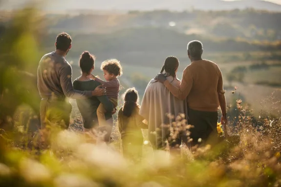 Rear view of African American multi-generation family looking at view while spending an autumn day on a hill.
